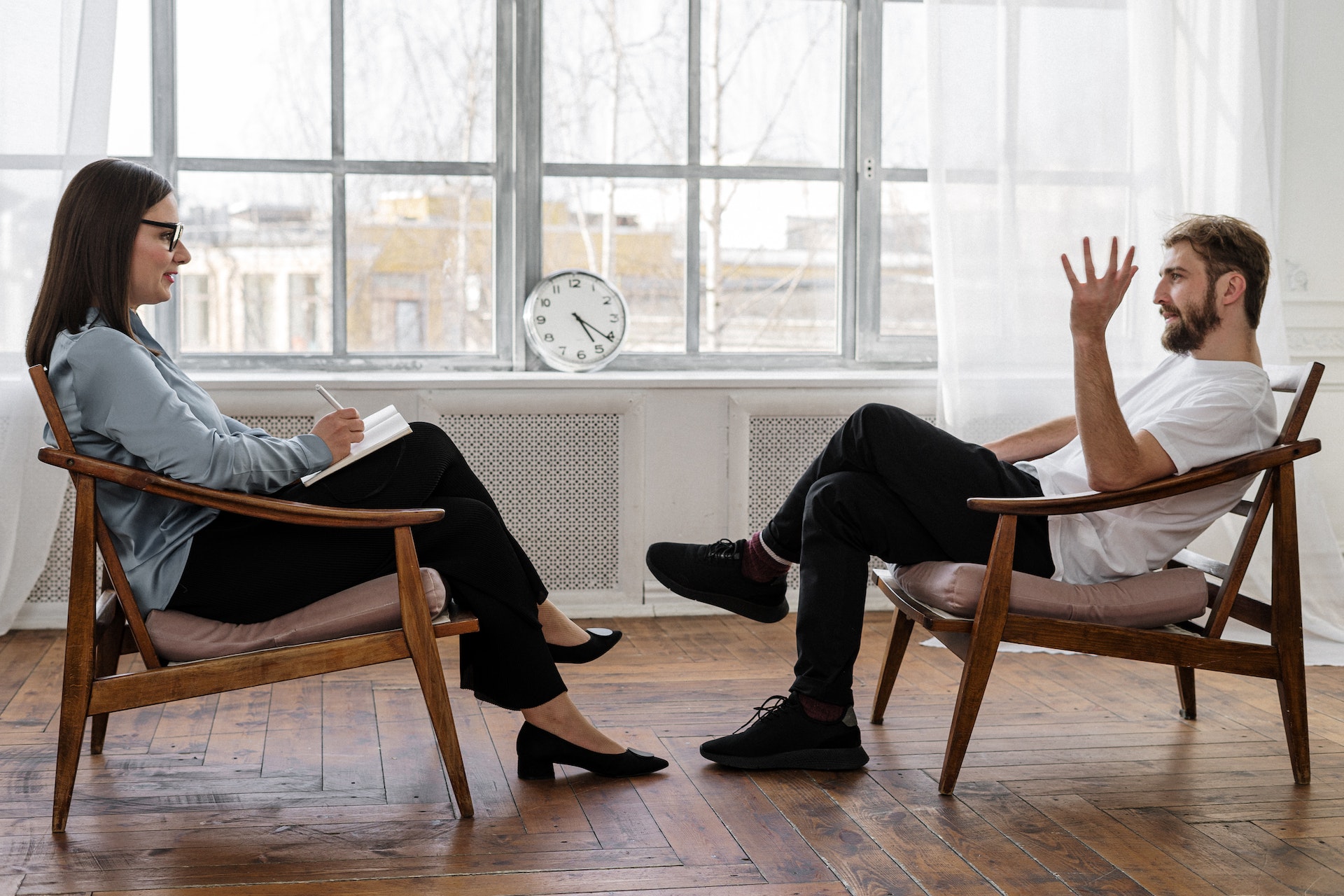 Two people sitting in chairs and talking